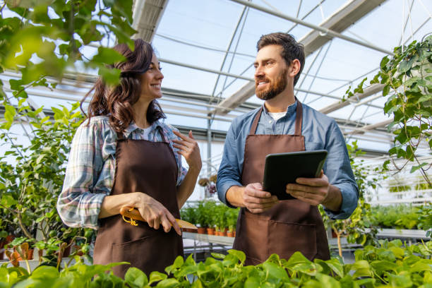 istock Greenhouse worker talking to a supervisor and looking involved 2190284276