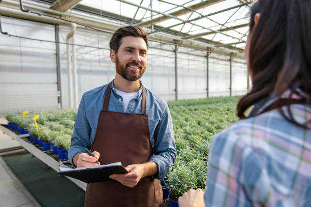 istock Glasshouse workers talking after quality control check and looking contented 2190284412