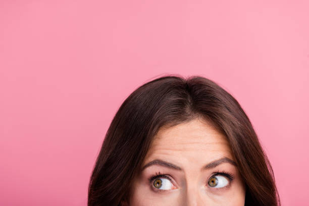 istock Playful curious young woman with expressive eyes glancing sideways against a bright pink background 2190285772