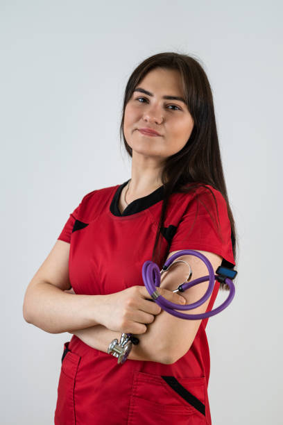 istock Young caucasian female doctor in red uniform  standing against grey background 2190285992