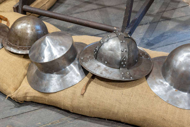 istock Reconstructed medieval helmets on a burlap sack, metal protective armor parts display, historical reenactment objects, ancient warfare equipment, handmade steel headgear middle ages reconstruction 2190287541
