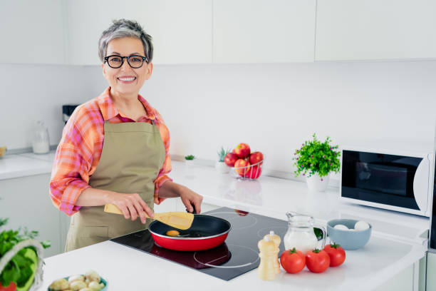 istock Charming senior woman cooks breakfast in a modern kitchen filled with daylight 2190288732