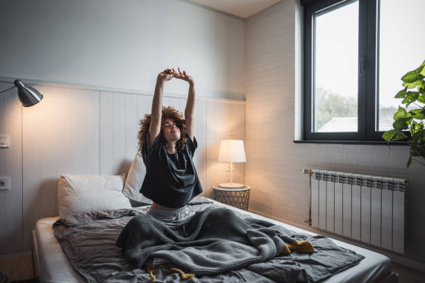 istock Young woman stretching in bed to start her day 2190290589