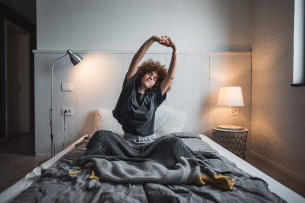 istock Young woman stretching in bed to start her day 2190290596
