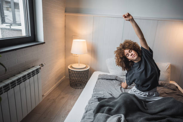 istock Young woman stretching in bed to start her day 2190290598