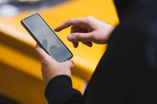 Person Interacting with a Smartphone Device Against a Vibrant Yellow Background