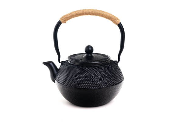 Traditional black asian cast iron kettle or teapot isolated on white background