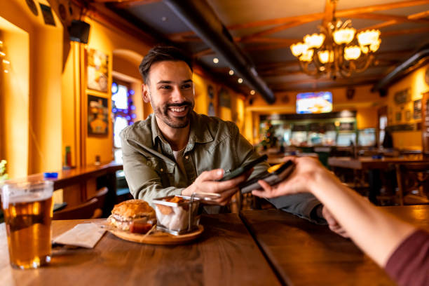 istock Happy customer paying contactless with mobile phone in restaurant 2190296821