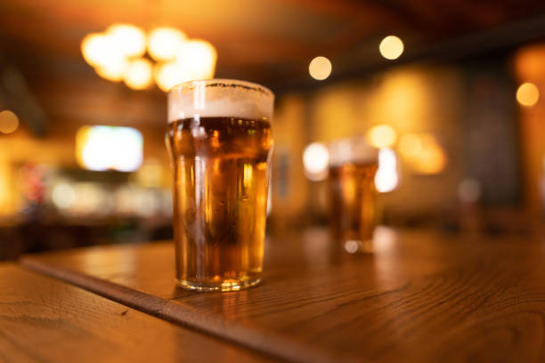 istock Refreshing beer glasses resting on wooden table in warmly lit pub 2190296954