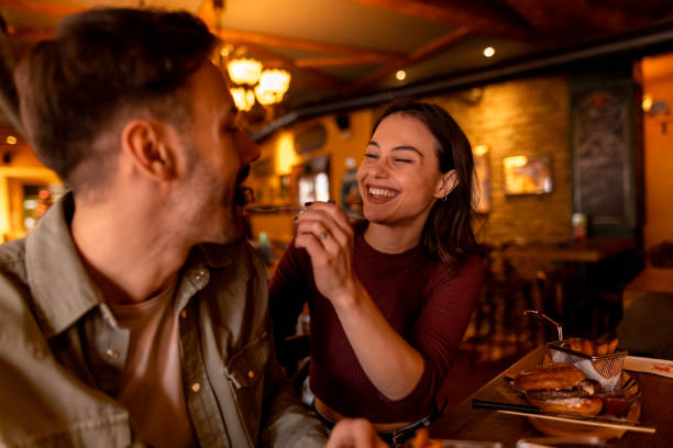 istock Happy couple sharing food, enjoying a romantic date at restaurant 2190297793