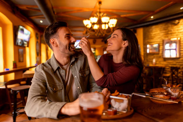 istock Happy couple sharing food and having fun at the pub 2190297840