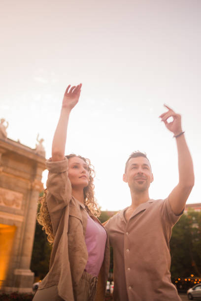 Young dancers are dancing swing in madrid, spain, in front of the puerta de alcala monument at sunset
