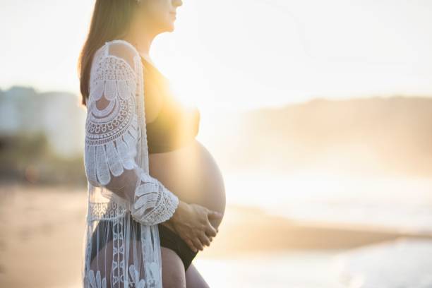 istock Pregnant woman enjoying the beach 2190303203