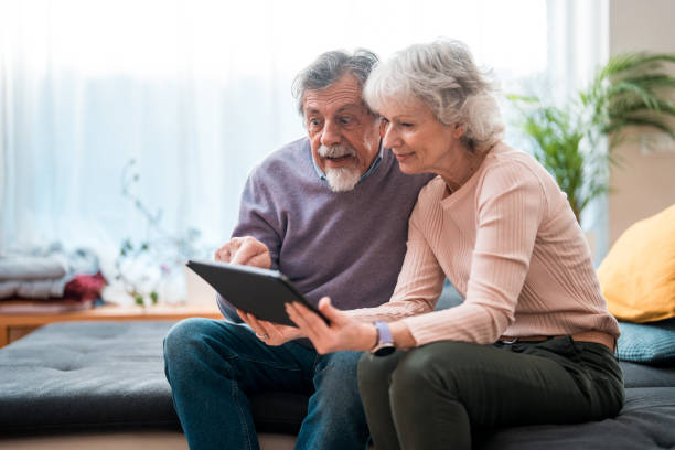 istock Elderly Couple Engaged with Technology at Home 2190306187