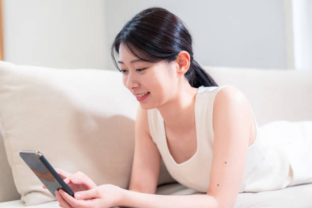 istock Young woman lying on the sofa and using her phone 2190310608