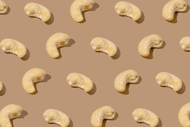 istock Creative pattern made with cashew nuts on beige background. Healthy food ingredient concept .Minimal style. flat lay. Top view 2190314056