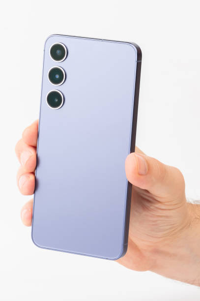 istock Hand holding modern smartphone with three camera lenses against white background 2190314130