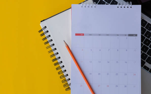 istock close up top view white calendar with schedule to make a new year resolution or manage timetable each day lay on laptop over yellow background for planning of goal concept 2190314131