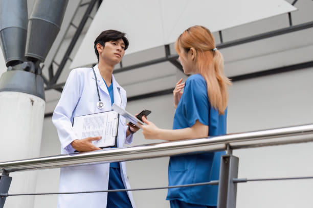 Healthcare professionals discuss patient care in medical facility indoor environment collaborative scene for seo impact A doctor and nurse engage in an important conversation about patient care in a contemporary healthcare setting. civil rights act stock pictures, royalty-free photos & images