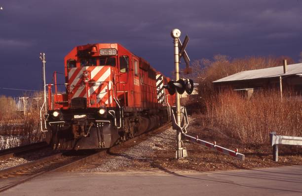 Warning gates are down as a freight train is about to cross Green Street in Plattsburgh, New York on April 15, 1994.  The train is heading north and has just passed the train station.