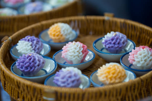 Spiral shaped multi colored marshmallows in small cake-stand on purple fabric at confectioner's
