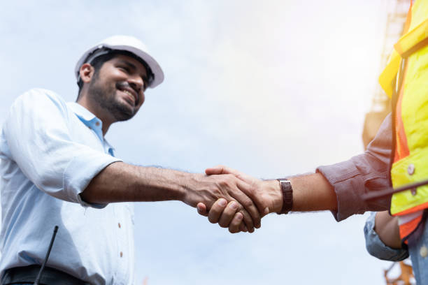 istock Group of male engineer construction putting their hands together at construction site. Teamwork of male construction builder at construction site. Unity and teamwork concept 2190322347