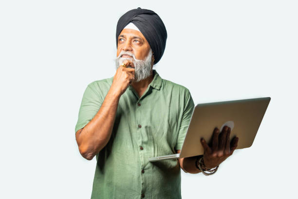 istock Indian Elderly Sikh man in casual wear using laptop while standing, showing confidence and success 2190322464