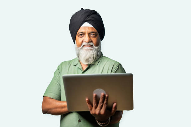 istock Indian Elderly Sikh man in casual wear using laptop while standing, showing confidence and success 2190322480