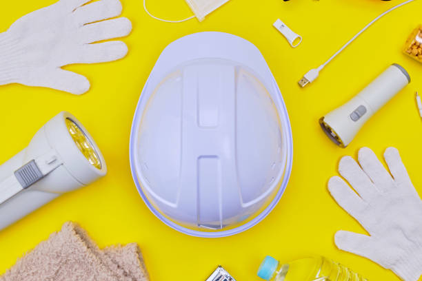 istock Safety helmet and disaster preparedness kit on yellow background. 2190323593