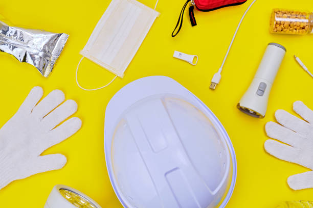 istock Safety helmet and disaster preparedness kit on yellow background. 2190323607