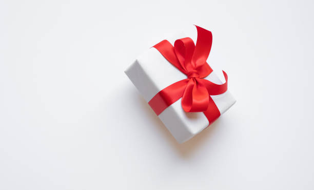 istock Simple white paper craft gift box with red ribbon bow in dynamic angle.anniversary and special day with present 2190324364