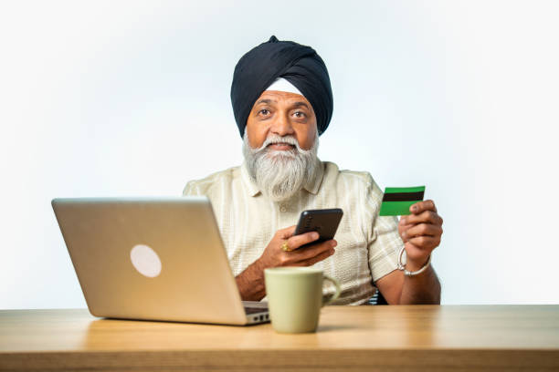 istock Senior Sikh man making online payments using a smartphone or laptop, promoting digital banking 2190329734