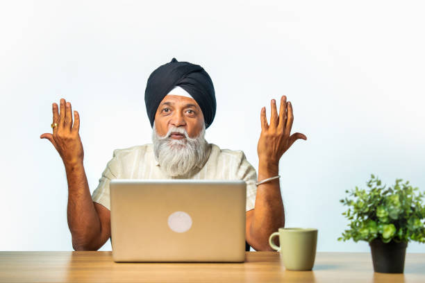 istock Senior Sikh man using laptop at home, pointing and showcasing a confident success gesture 2190329883