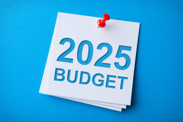 istock Budget 2025 Word in White Sticky Note on Blue Chardboard Background 2190332091
