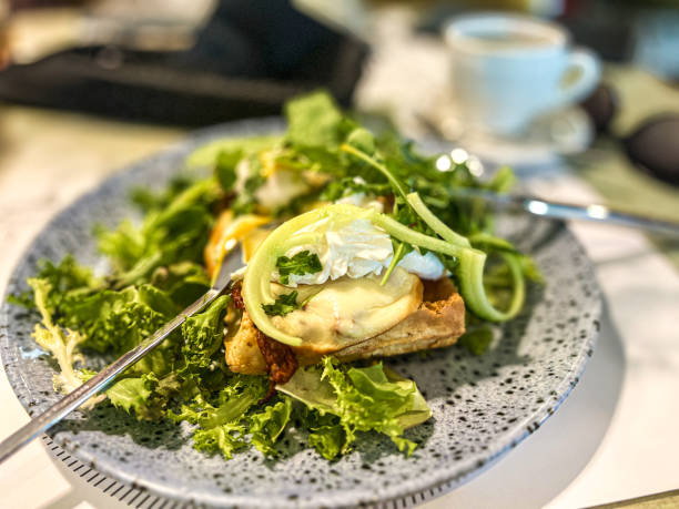 istock Green salad with poached egg on a toast and mozzarella cheese on a plate in restaurant. 2190335165