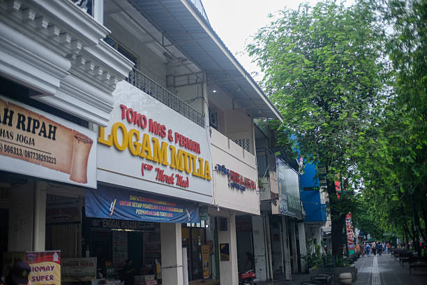 A row of shops along a tree-lined street, featuring prominent signage for 