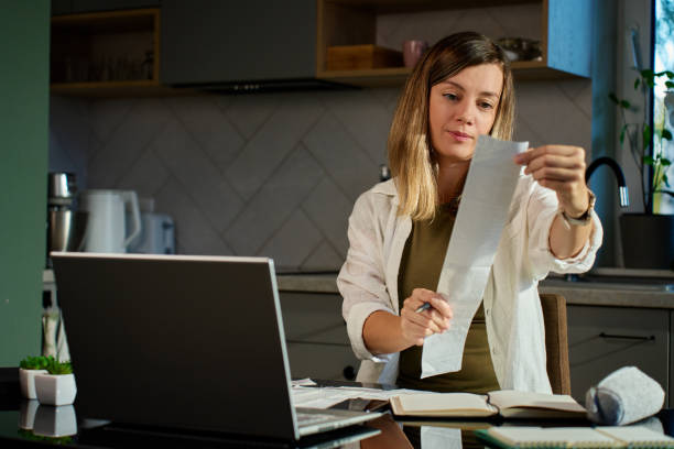 istock Stressed woman covering her face with hands over unpaid bills 2190337358