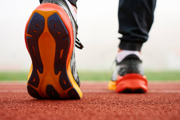 istock Runner wearing modern sport shoes standing on track surface 2190337369