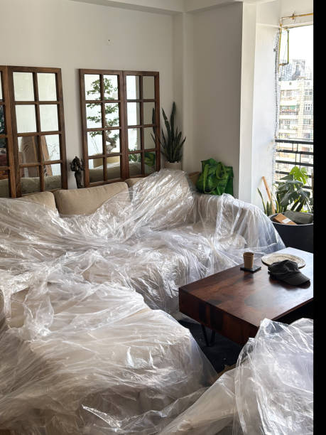 istock Image of decorating chaos / sofa covered in plastic protection, messy, untidy room with dust and paint, home renovation, painting project 2190338188