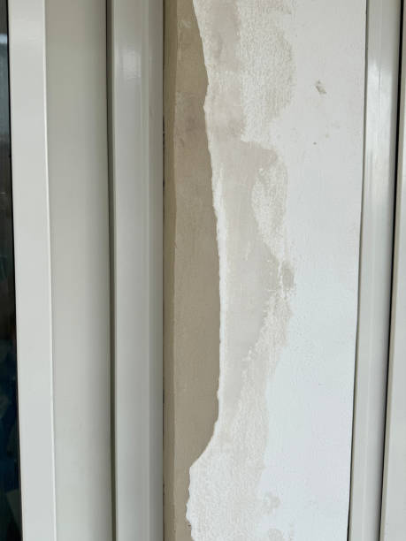 istock Image of repaired plastered walls with badly filled areas, broken plaster, raw plugs, poorly installed windows and brickwork 2190339930
