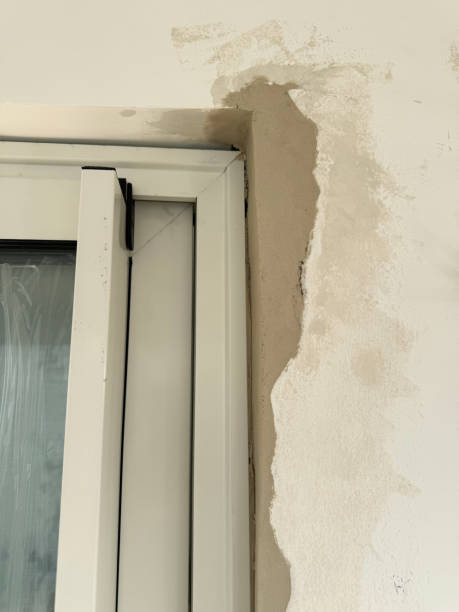 istock Image of badly repaired plastered walls with poorly filled areas, plaster, brickwork exposed, substandard window installation 2190339956