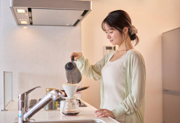 istock A young woman brewing coffee by hand in the kitchen. 2190339986