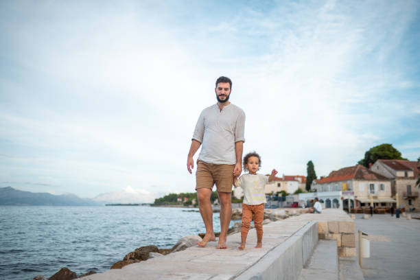 Grandfather carrying his grandson on shoulder on the beach