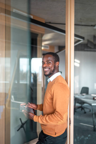 istock Confident Black Businessman Engages with Digital Tablet in Office Hallway 2190342234
