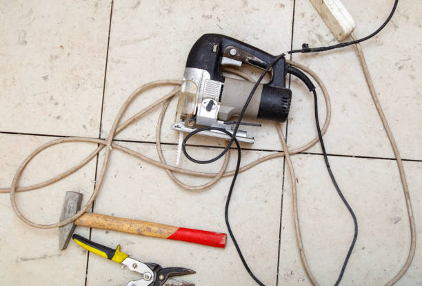 istock A corded power tool is laying on the floor next to a hammer 2190343385