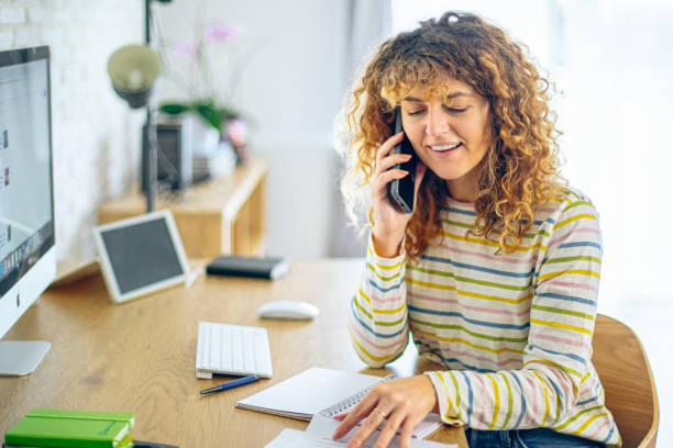 istock Young female entrepreneur talking on phone and working from home 2190350477
