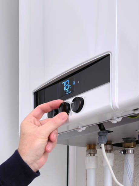 istock A man sets the temperature on a modern digital gas boiler in a house. 2190352121