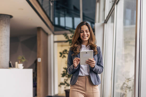 istock Smiling businesswoman in modern office holding tablet 2190352479