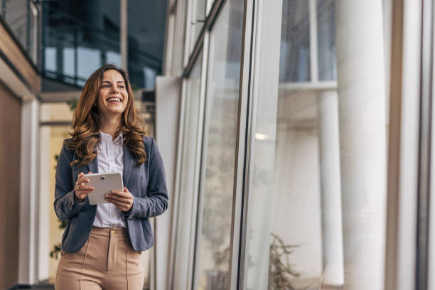 istock Smiling businesswoman in modern office holding tablet 2190352602