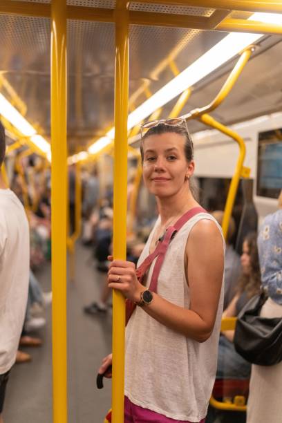 istock Woman in subway car holding handrail 2190353040